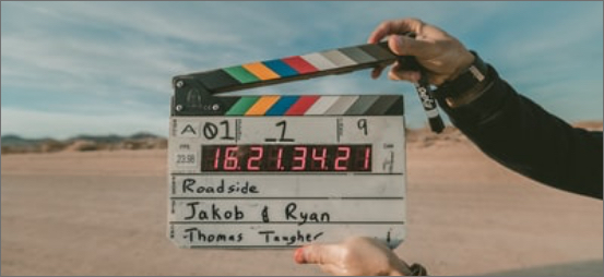 Hand holding clapperboard. Desert locale